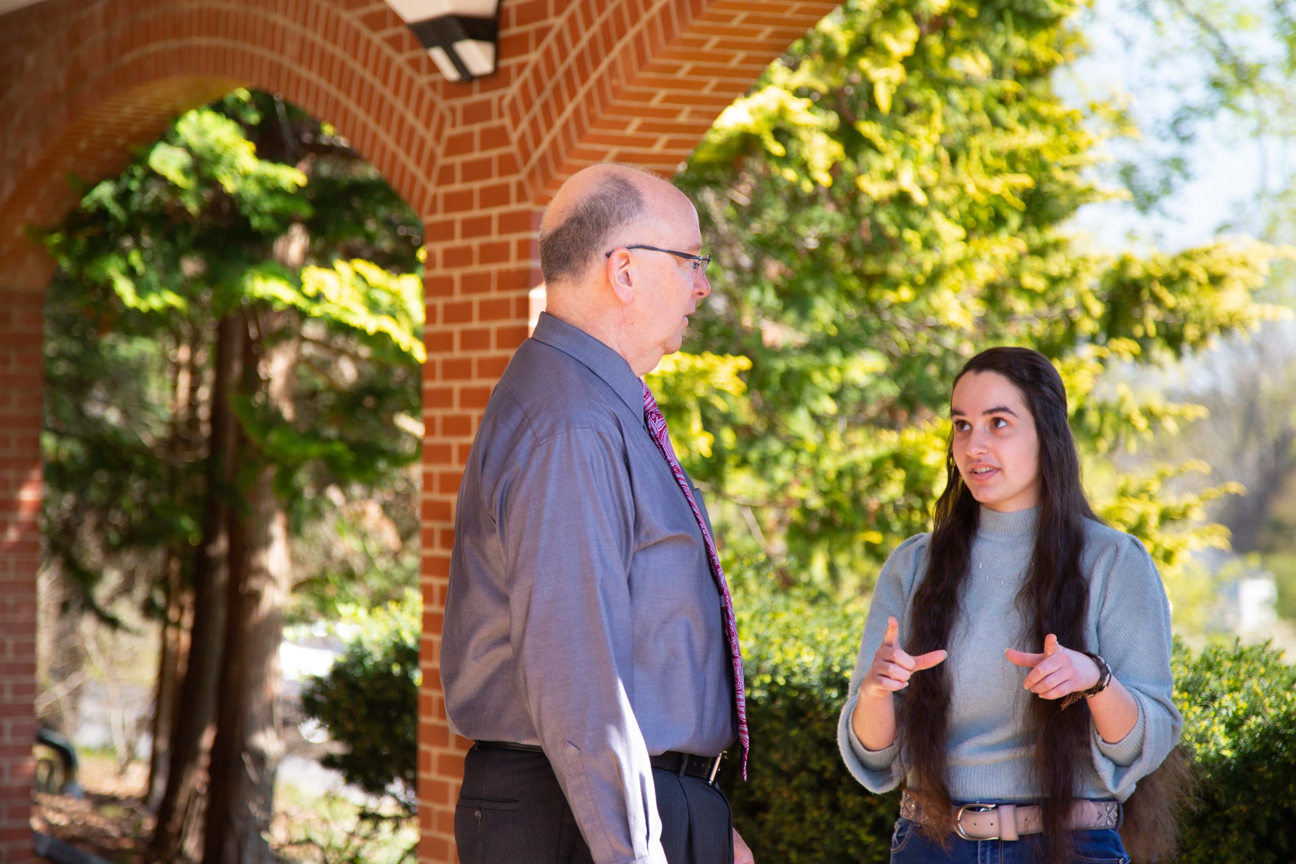 Accounting professor Bob Mahan talks with student after class.